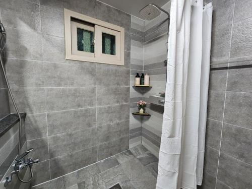 a bathroom with a shower with a shower curtain at Sunshine Aewol Entire House in Jeju