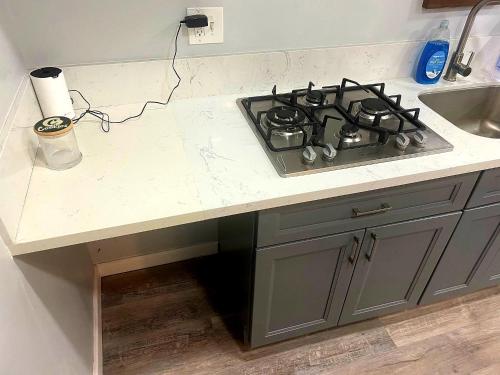 a kitchen counter with a stove and a sink at We are in this together in Santa Ana