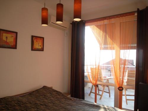 ソゾポルにあるBudzhaka Apartment Africaのベッドルーム1室(ベッド1台付)、窓、バルコニーが備わります。