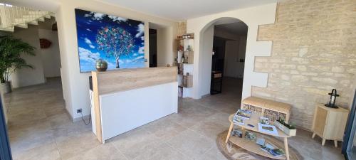 una habitación con una pared con una pintura de un árbol en A la Gloriette, en Neuville-du-Poitou