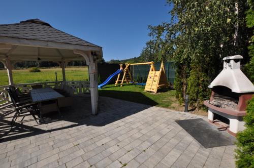 a patio with a pavilion and a playground at Apartamenty Sowiogórskie in Pieszyce