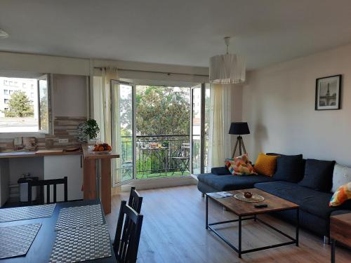 un salon avec un canapé bleu et une table dans l'établissement Stade de France 6 pers, à Saint-Denis