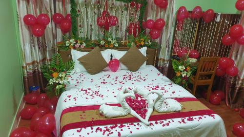 1 dormitorio con 1 cama con corazones y globos en London House Resort en Birātnagar