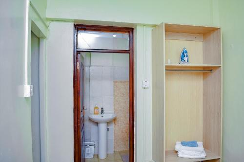 y baño con lavabo, ducha y aseo. en Belaire BnB Syokimau, en Nairobi