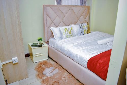 1 dormitorio con cama y mesita de noche con cama sidx sidx en Belaire BnB Syokimau, en Nairobi