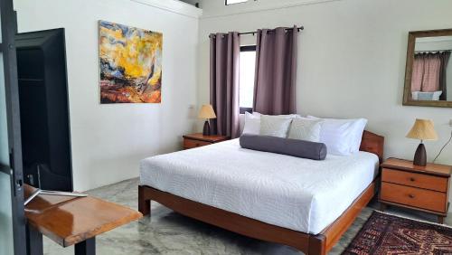 ヤオノイ島にあるAn Pao Beach Residence Villa 1 - Koh Yao Noiのベッドルーム1室(ベッド1台付)が備わります。壁には絵画が飾られています。
