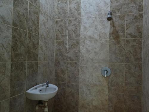 La salle de bains est pourvue d'un lavabo et d'une douche. dans l'établissement OYO 93046 Hotel Fortuna Parepare, à Parepare