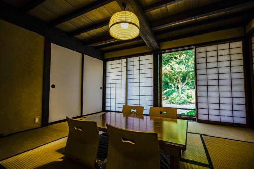 a dining room with a table and chairs and a window at 甘糟屋敷 Amakasu Yashiki KAMAKURA in Kamakura