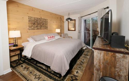 1 dormitorio con 1 cama y TV de pantalla plana en Bearly Behavin, en Gatlinburg