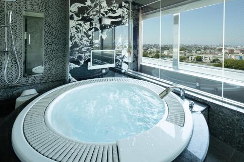 a bath tub in a bathroom with a large window at Hotel BVLJUA -レジャーホテル- in Kurume