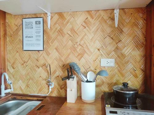 a kitchen counter with utensils on a wall at El Nido Backpackers Guesthouse in El Nido