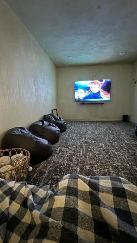 a living room with bean bags and a flat screen tv at The Gate in Sur