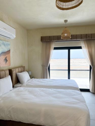 a bedroom with two beds and a large window at The Gate in Sur