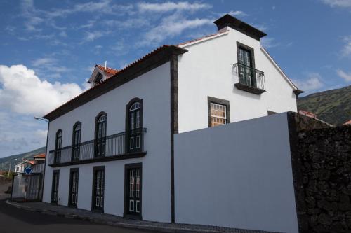 a white building with a clock on the side of it at Pico da Saudade in Prainha de Baixo