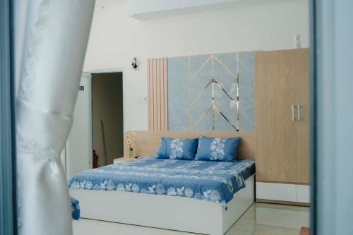 a bedroom with a bed with blue pillows at Arina Luxury Hotel - Vincom Tay Ninh in Tây Ninh