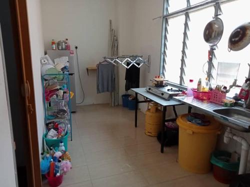 eine Küche mit einer Theke, einer Spüle und einem Kühlschrank in der Unterkunft Dena Moon inn in Kota Bharu