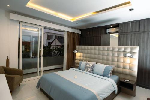 Schlafzimmer mit einem Kingsize-Bett und einem Stuhl in der Unterkunft The Samya Villa, Berawa Canggu in Denpasar