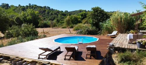 a swimming pool on a wooden deck with chairs around it at Anexo Casa São Miguel the beauty of imperfection in Santarém