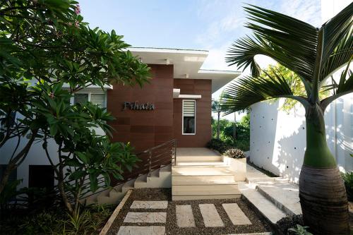 una casa con una palmera delante de ella en One Hagdan Villas en Boracay