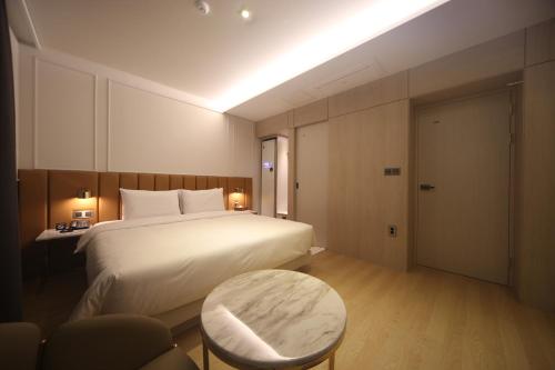a hotel room with a bed and a table at H Avenue Hotel Minam in Busan