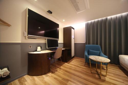Televízia a/alebo spoločenská miestnosť v ubytovaní H Avenue Hotel Minam