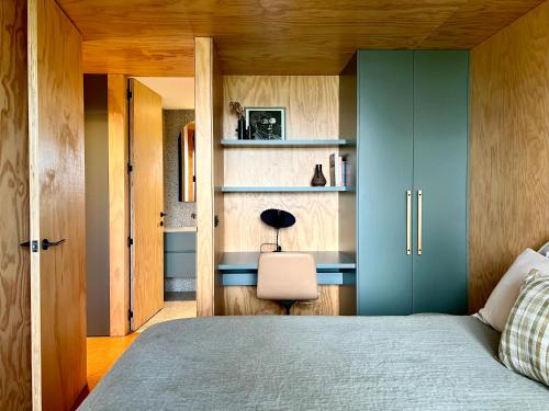 1 dormitorio con 1 cama con armarios azules y silla en Bridge Rest, en Wye River