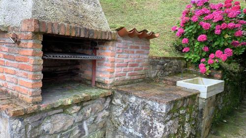 a brick oven with a sink in a garden at LA QUINTA DE PUELLES in Ambás