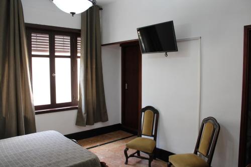 um quarto com uma cama e uma televisão na parede em Tenerife BnB em La Laguna