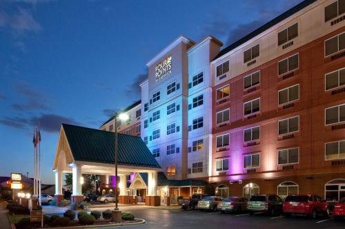 a hotel with cars parked in a parking lot at Four Points by Sheraton Louisville Airport in Louisville