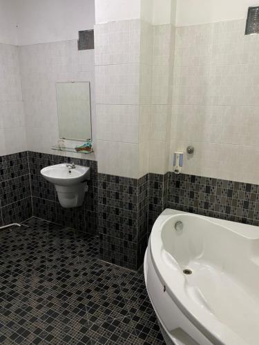 a bathroom with a tub and a sink and a toilet at Thanh Binh hotel in Ho Chi Minh City