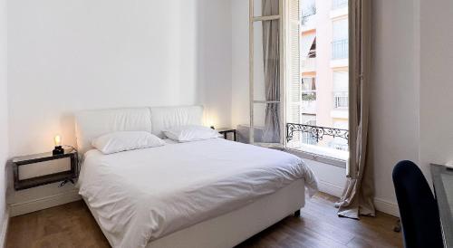 Cama blanca en habitación con ventana en Chambre moderne proche Monaco G en Beausoleil