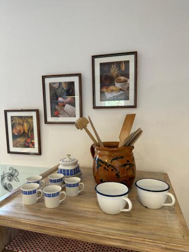 a table with a bunch of cups and a vase on it at Hiša Srečo in Begunje na Gorenjskem