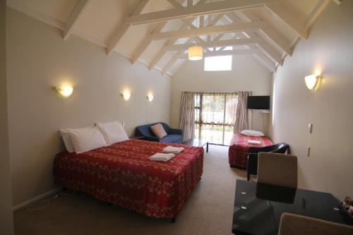Habitación de hotel con cama y silla en Apex on Fenton, en Rotorua