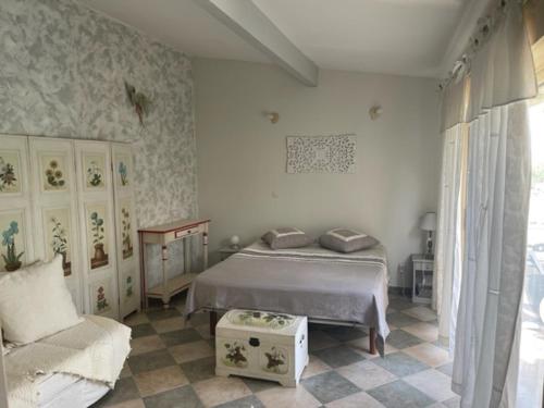 une chambre avec un lit et un canapé dans l'établissement appartement avec piscine, à Arpaillargues-et-Aureillac