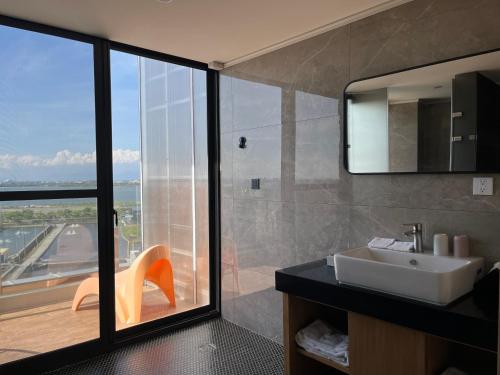 a bathroom with a sink and a shower with a view at 緩慢大鵬灣 in Donggang