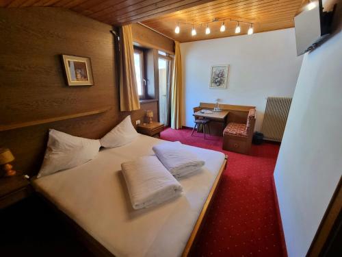 a bedroom with a bed with two pillows on it at Pension Sattlerenglhof in Laces