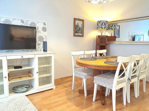a dining room with a table and a tv at Apartament Trzy Sypialnie Stare Miasto in Elblag