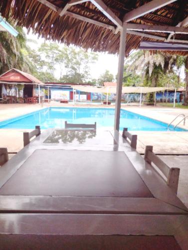 a large swimming pool with benches and a swimming pool at Lodge del Abuelo - Divina Montaña in Pucallpa