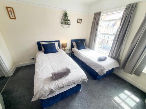 two twin beds in a room with a window at Springfield Place - 3 Bed Cent Reading - Long term savings - Free Parking in Reading