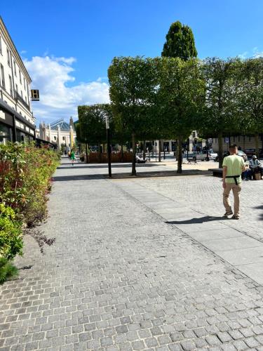 a man walking down a cobblestone street at appartement Disneyland paris val d Europe la vallée village parking 600m gare RER in Montévrain