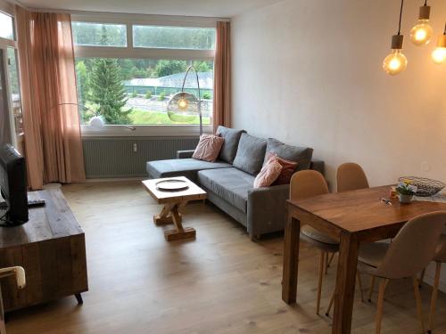 a living room with a couch and a table at Zu Hause am See - Pool, Sauna, Fitnessraum in Schluchsee