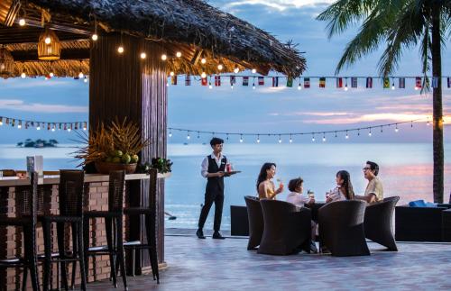 富國的住宿－富國芬珍珠度假酒店及Spa，一群人坐在海滩上的桌子上