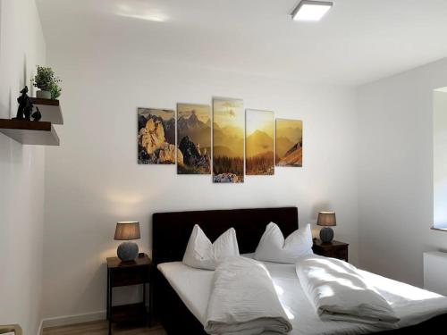 sypialnia z łóżkiem z czterema obrazami na ścianie w obiekcie Entspannen am Großen Goitzschesee inkl. Netflix w mieście Holzweißig