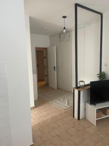een woonkamer met een spiegel en een tv bij Appartement à 100 m de la gare in Port-de-Bouc