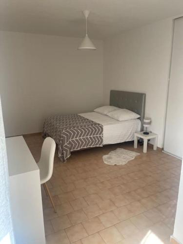 um quarto com uma cama e piso em azulejo em Appartement à 100 m de la gare em Port-de-Bouc