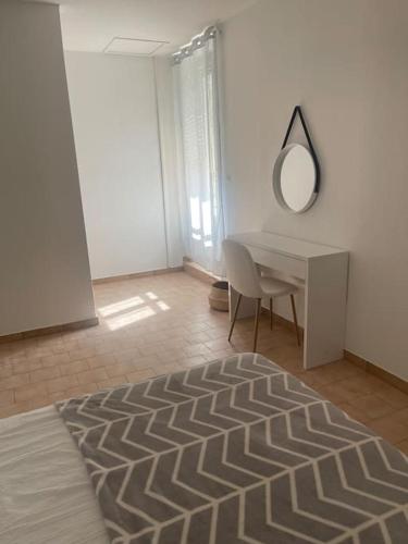 um quarto branco com uma secretária e um espelho em Appartement à 100 m de la gare em Port-de-Bouc