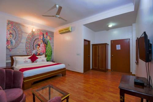 1 dormitorio con cama, sofá y TV en Hotel Parv en Jaipur