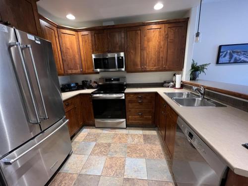 a kitchen with wooden cabinets and stainless steel appliances at Trappers Landing #34 in Sun Peaks