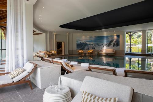 a living room with a swimming pool and chairs at Hôtel Royal in Évian-les-Bains