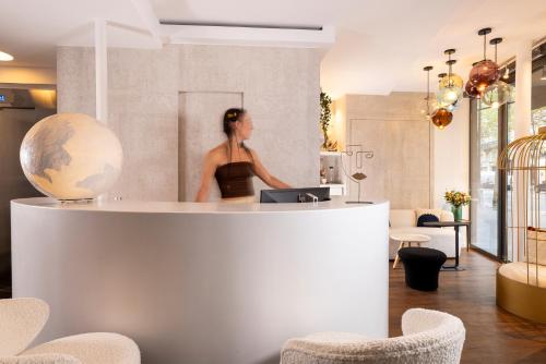 a woman standing behind a counter in a room at Hotel Chavanel in Paris